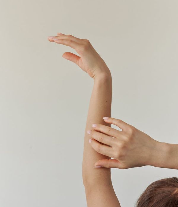 Woman in a peaceful yoga pose against a light background.